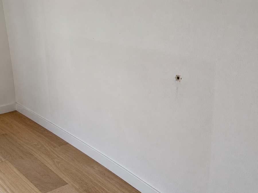 Photo : trou de cheville dans le mur de la chambre